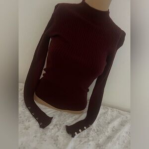 Burgundy long sleeve turtle neck top with buttons on lower sleeve